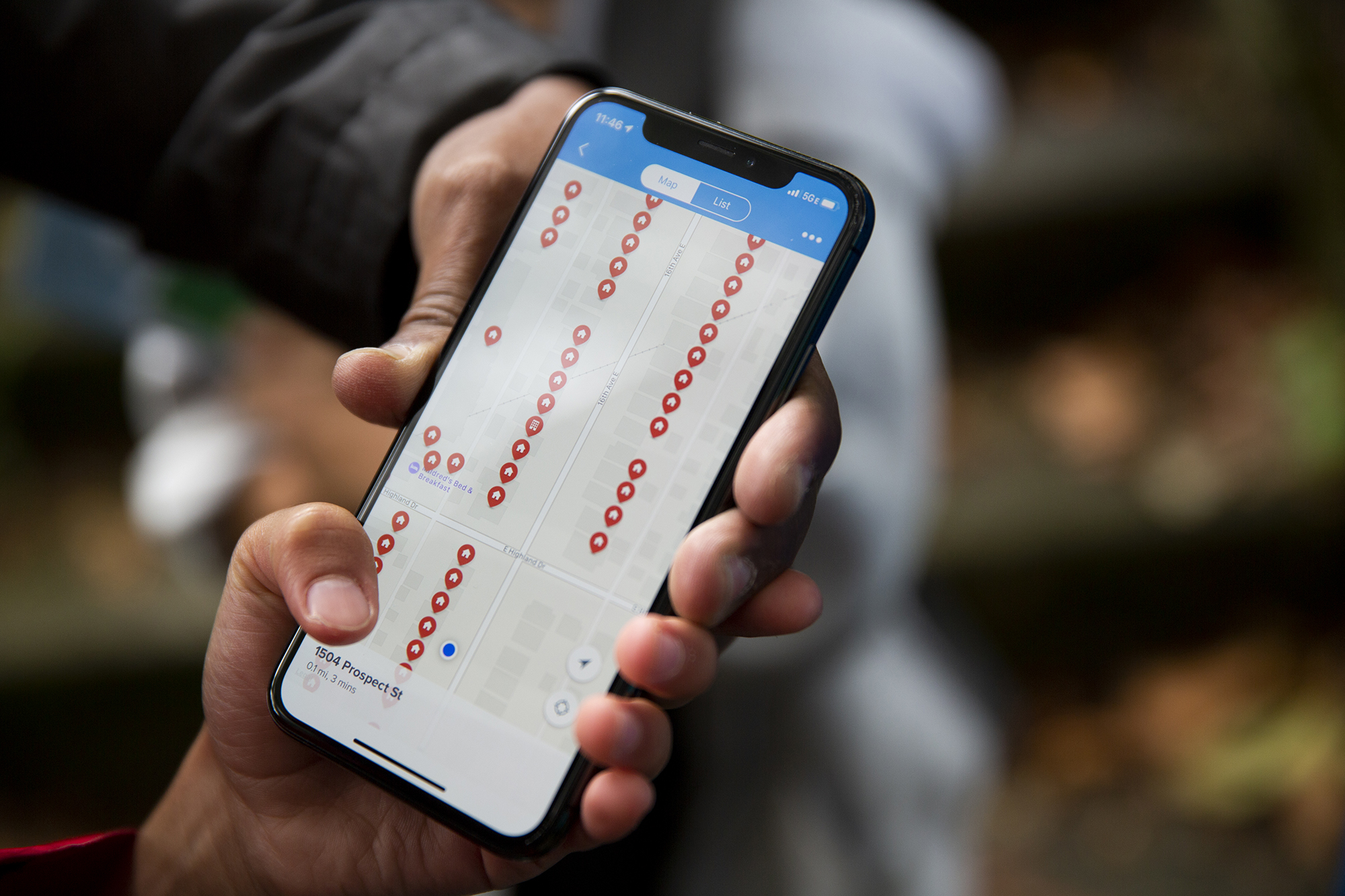 A volunteer holds a smart phone showing a map of households visited by the campaign.