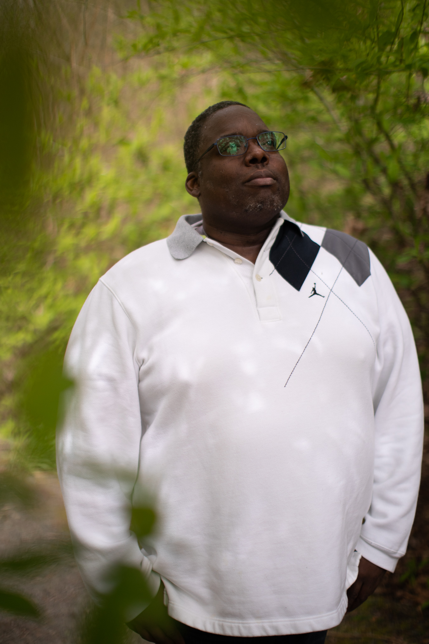 Man with white shirt and glasses in greenery