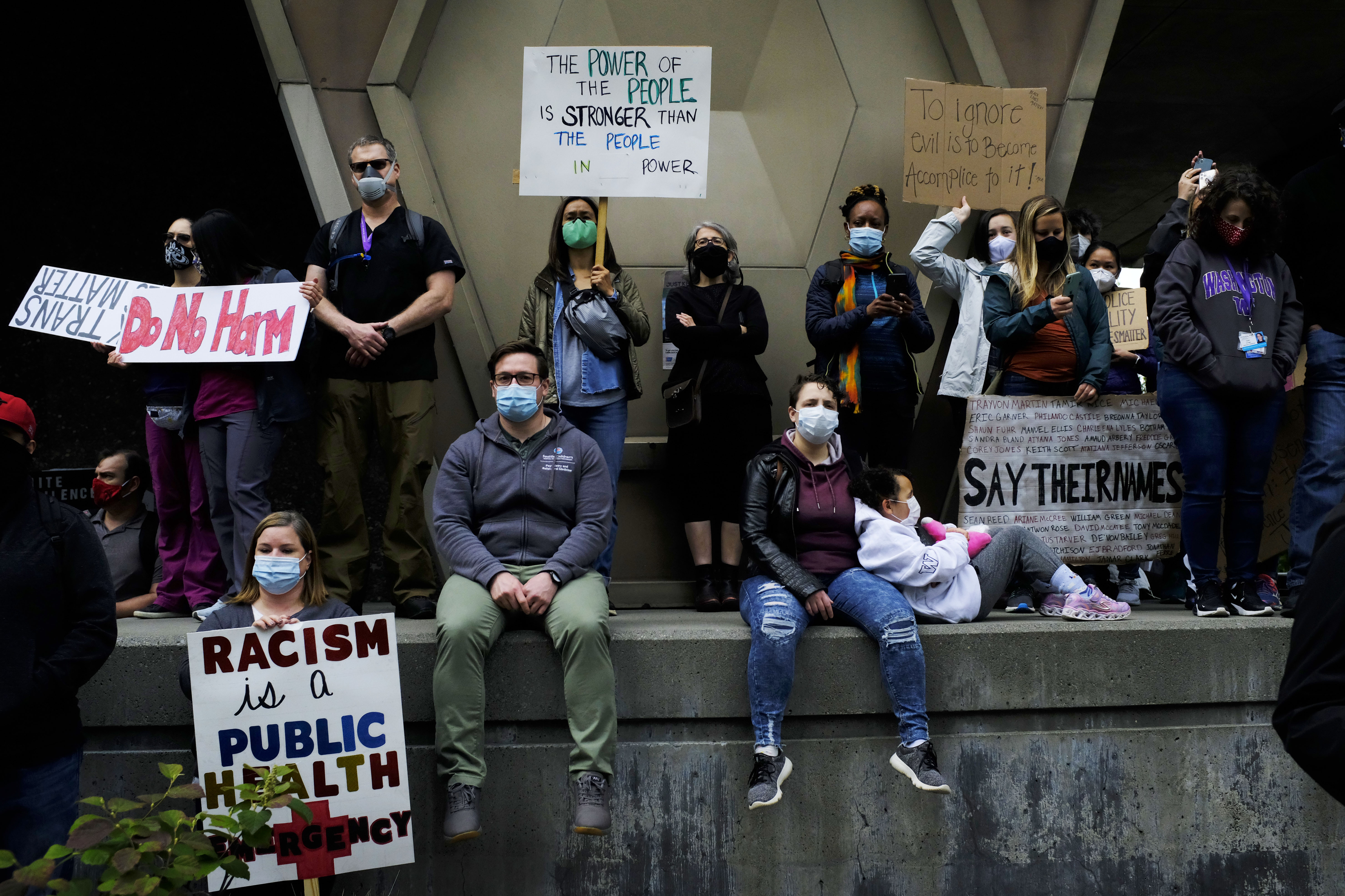 people sitting on concrete during protest