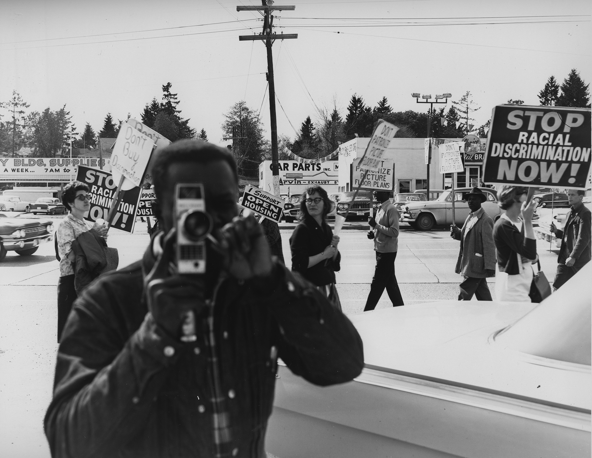 A man behind a camera during a protest