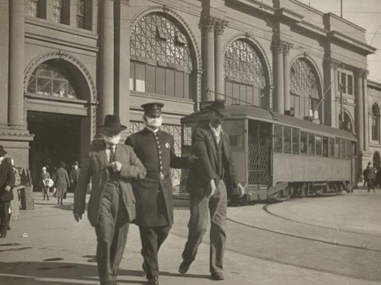 a police officer escorts two men to jail