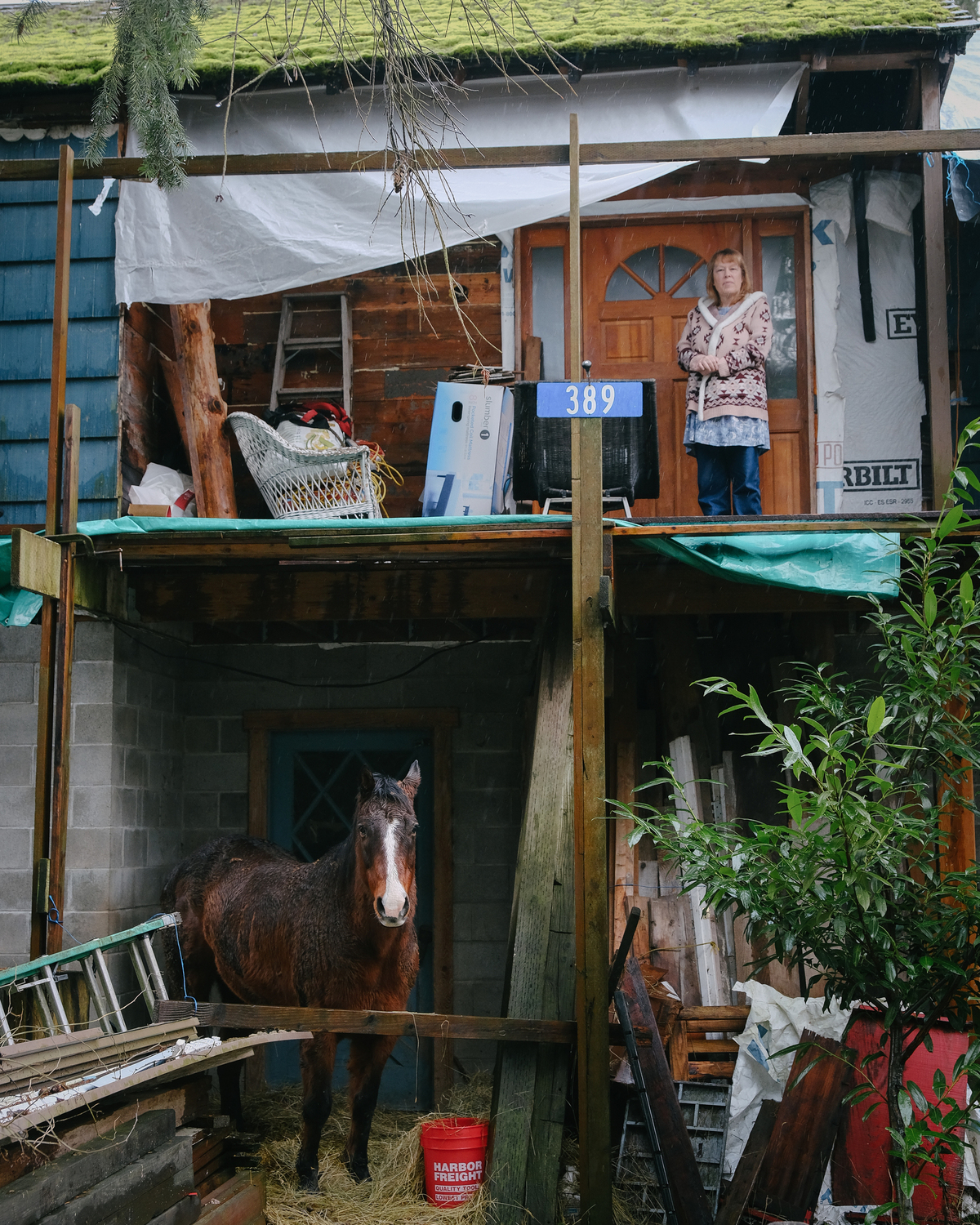 A woman stands on her porch