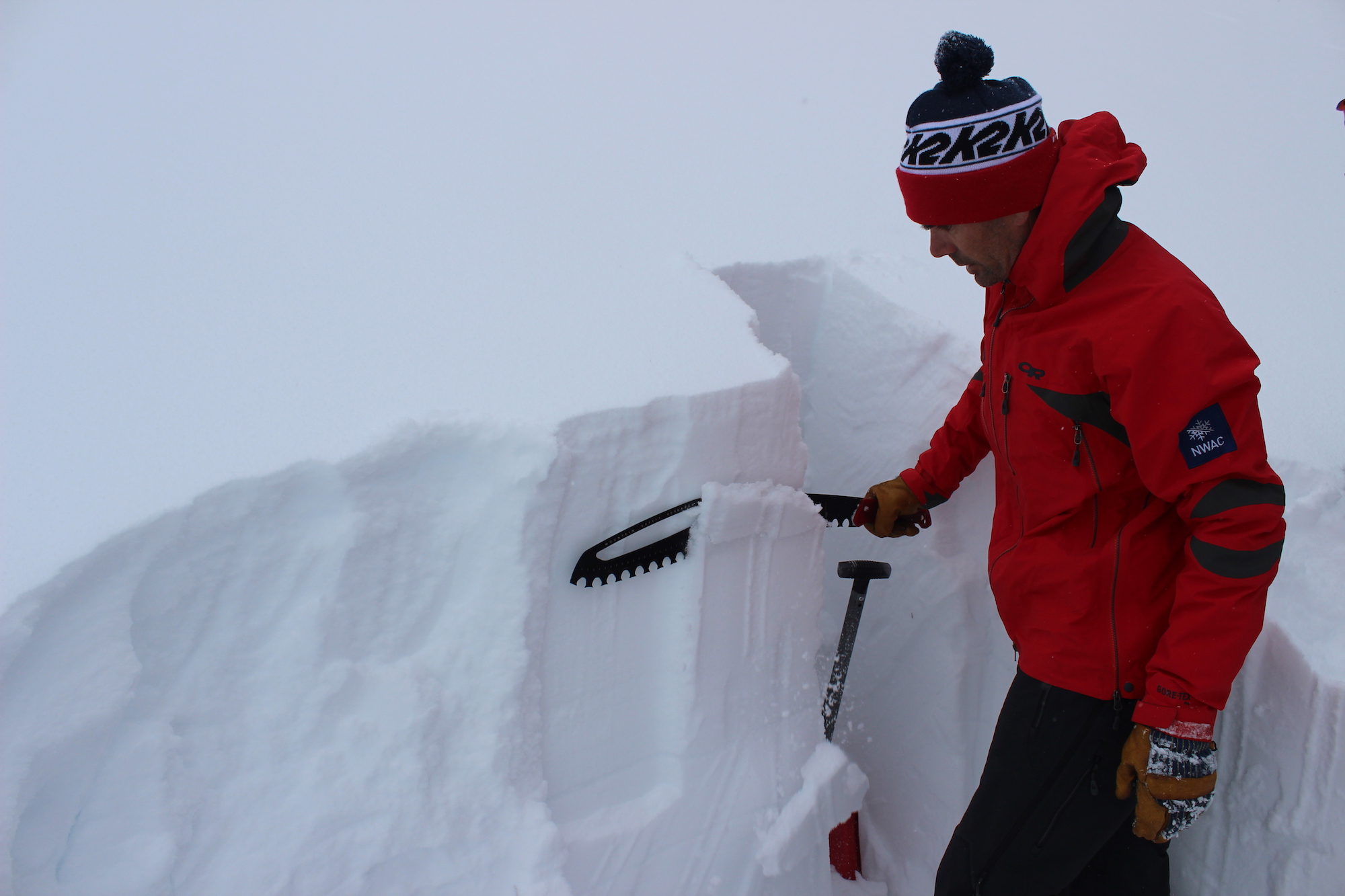 Allyn saws down the snow in a test pit to check for stability.