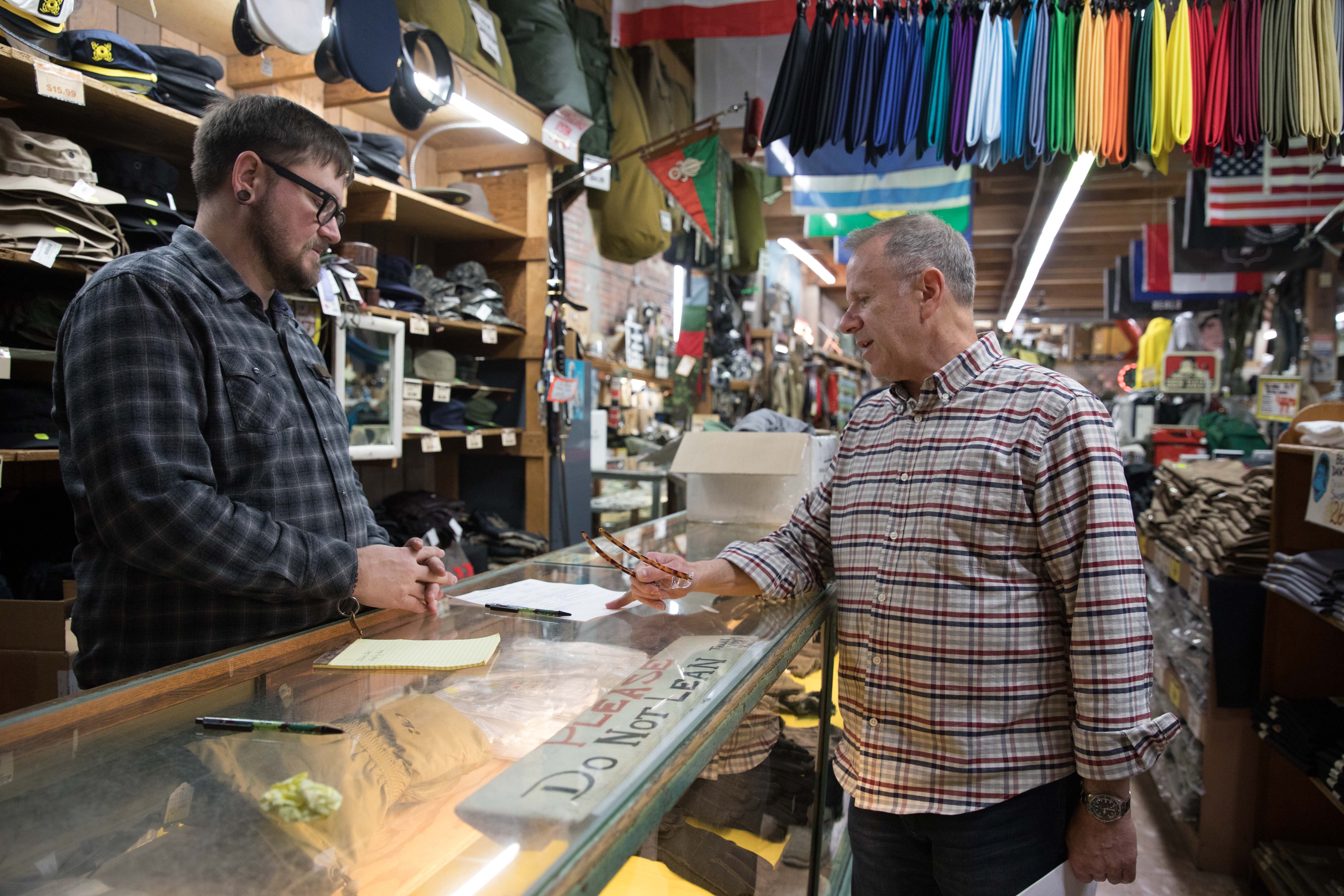 A man walks out the door of the Federal Army & Navy Surplus store in Seattle's Belltown neighborhood, April 19. 