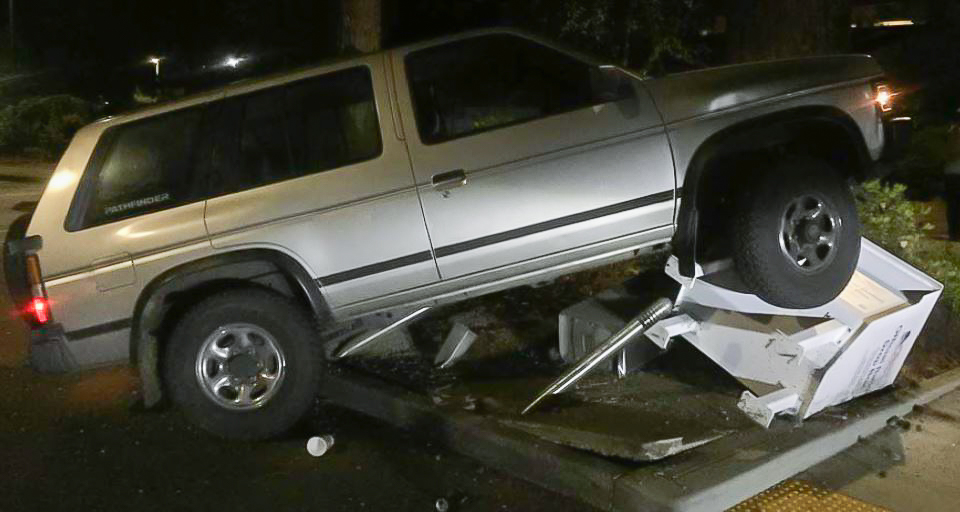 A Nissan Pathfinder sits atop a fallen ballot box in Lacey.