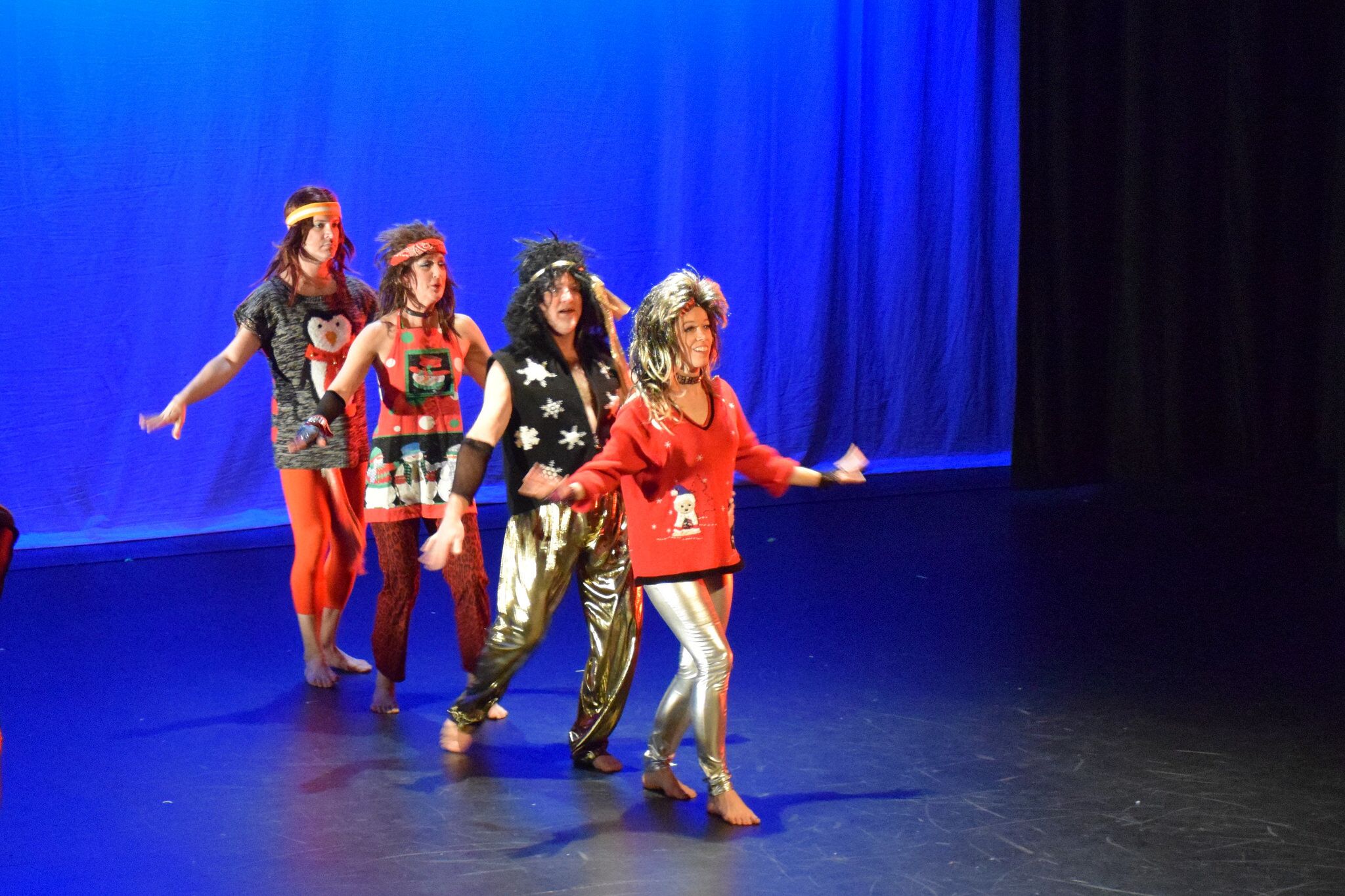 Four dancers in Christmas sweaters