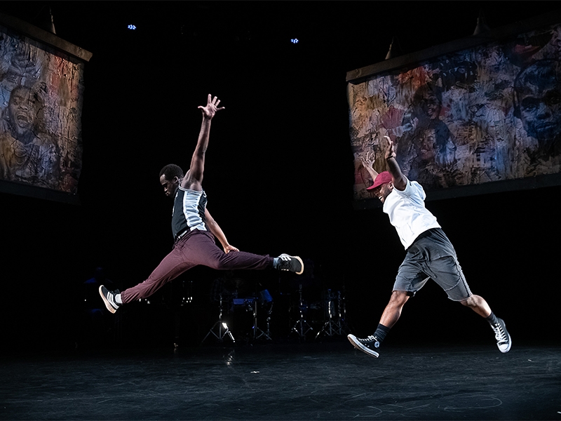 two dancers leaping on stage