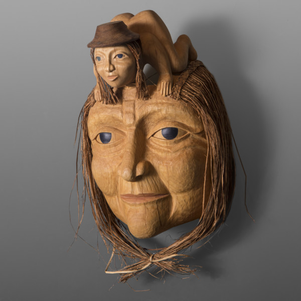 wood carving of a woman's face with a child on forehead