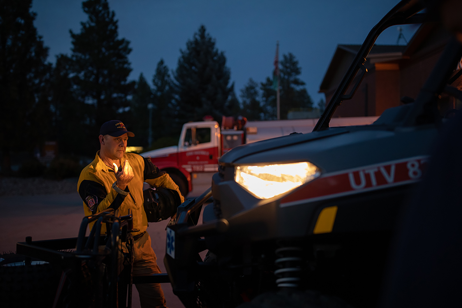 Tom Hatley directs a truck forward, lit up by the headlights.