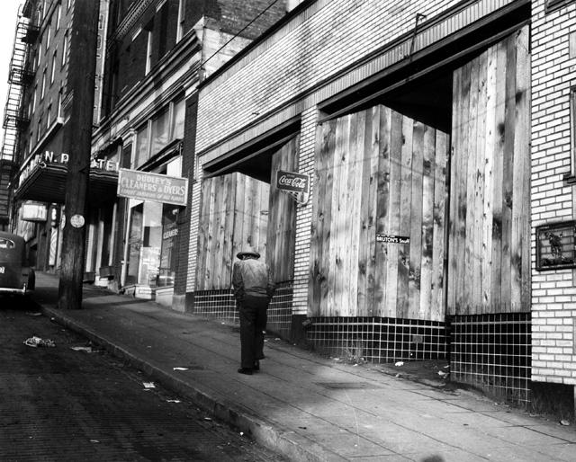 Black and white image of man walking on empty street in Japantown