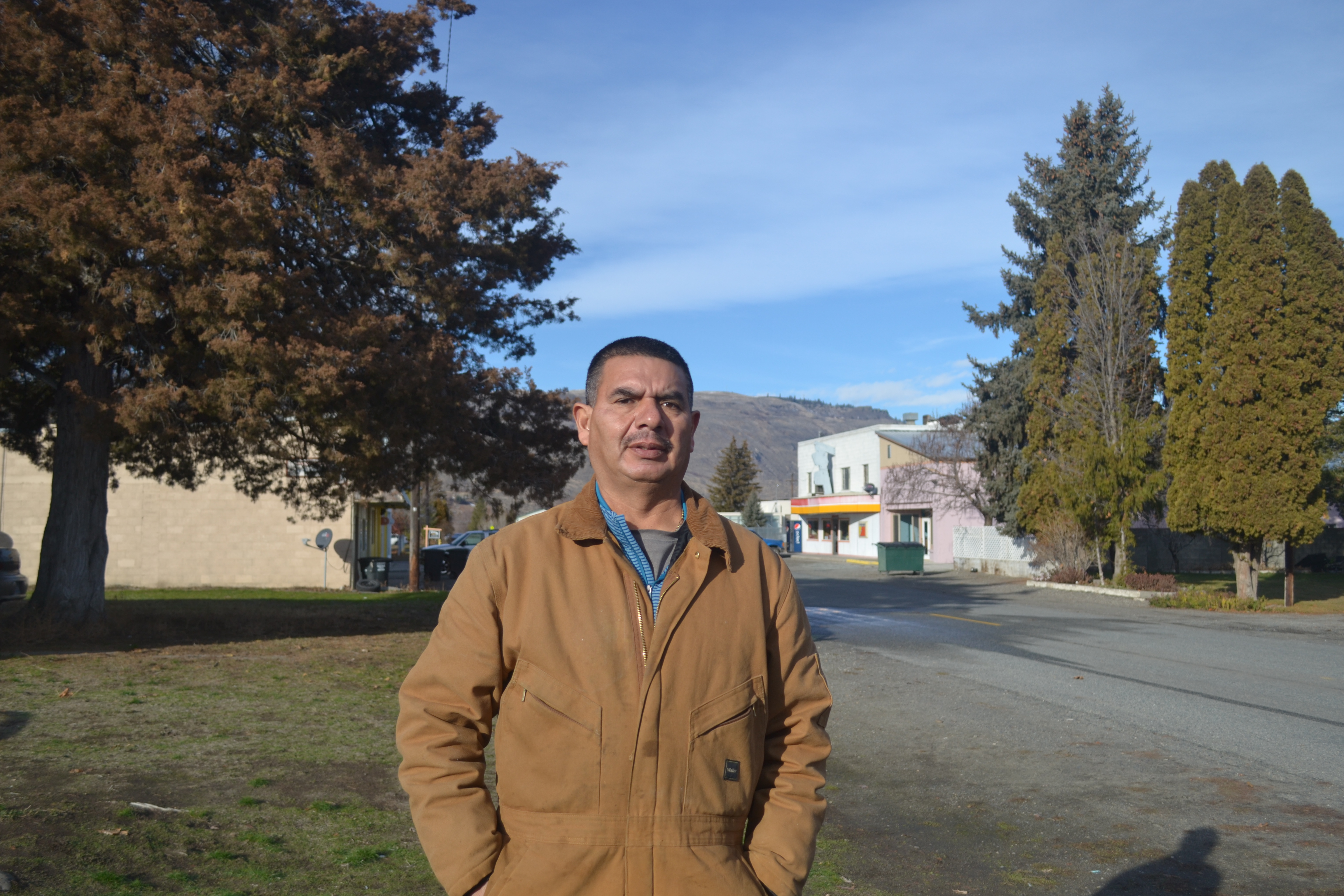 Manuel Farias stands outside his home