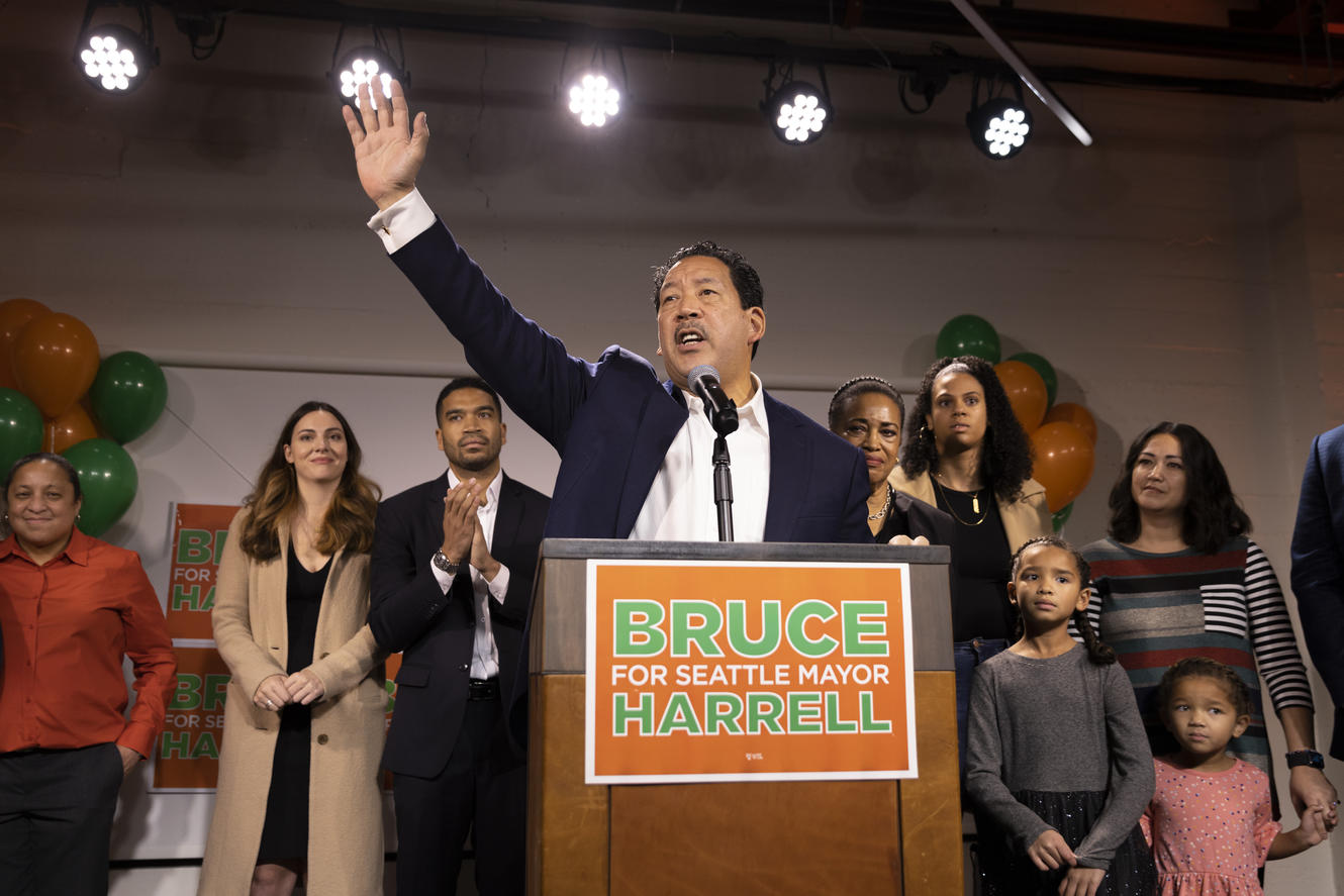 Seattle mayor-elect Bruce Harrell waves his hand from a stage