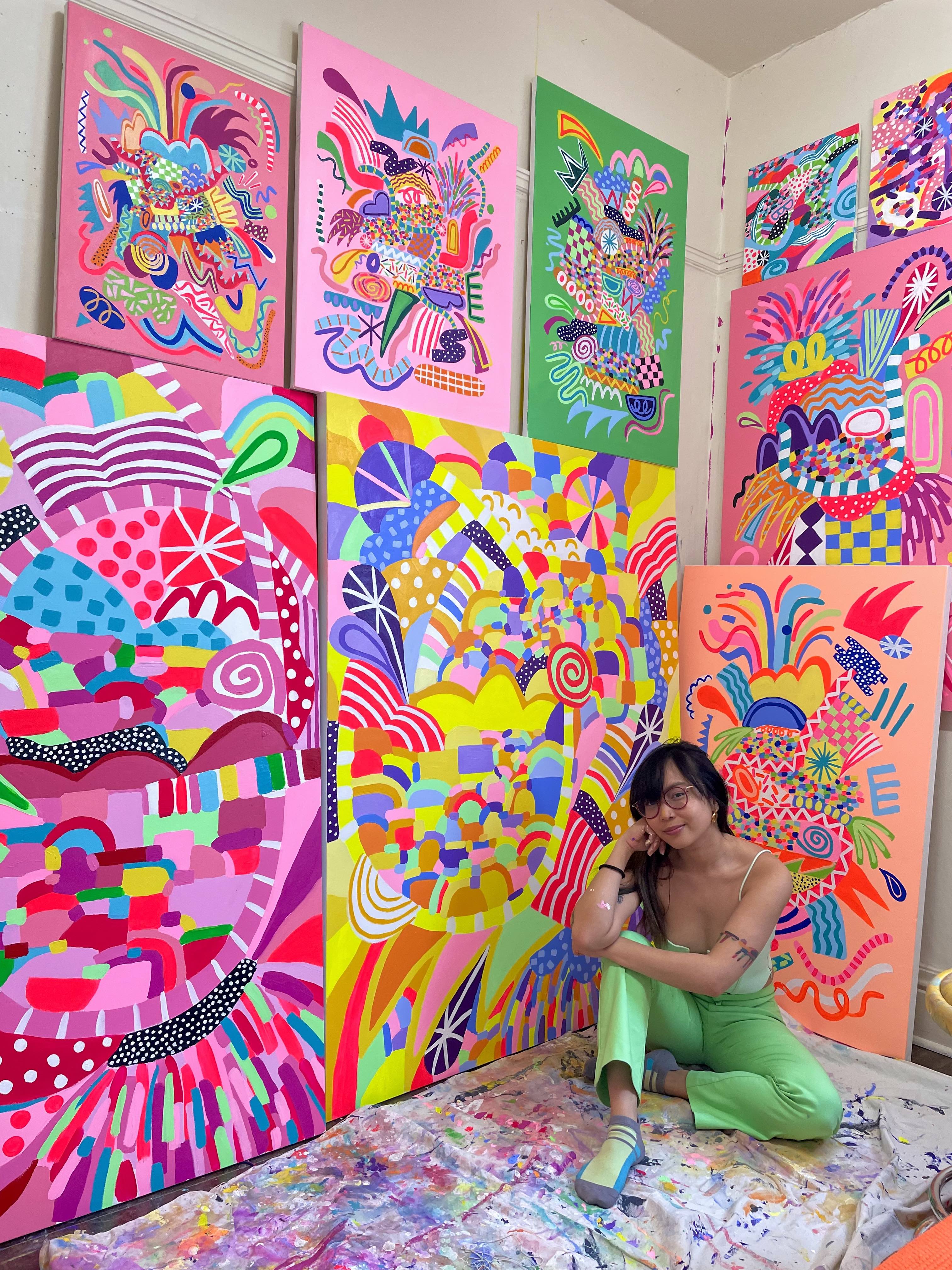 Person in front of six colorful paintings