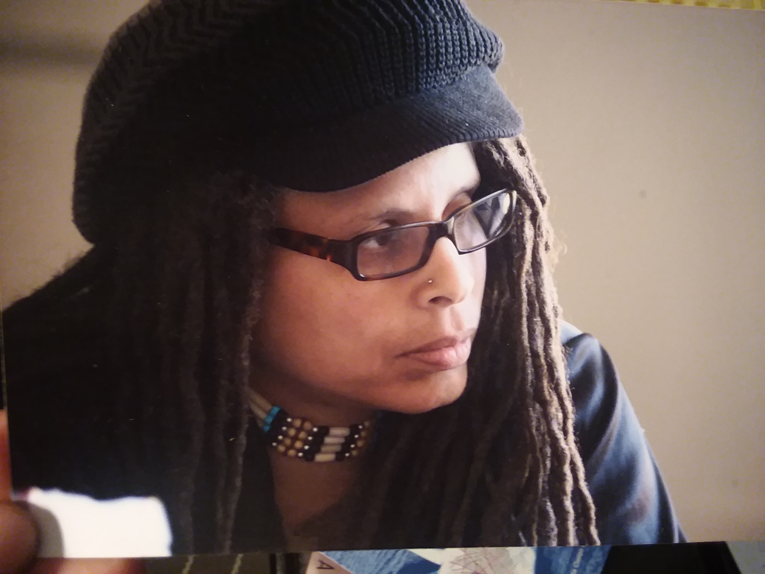 a woman in dreadlocks and hat