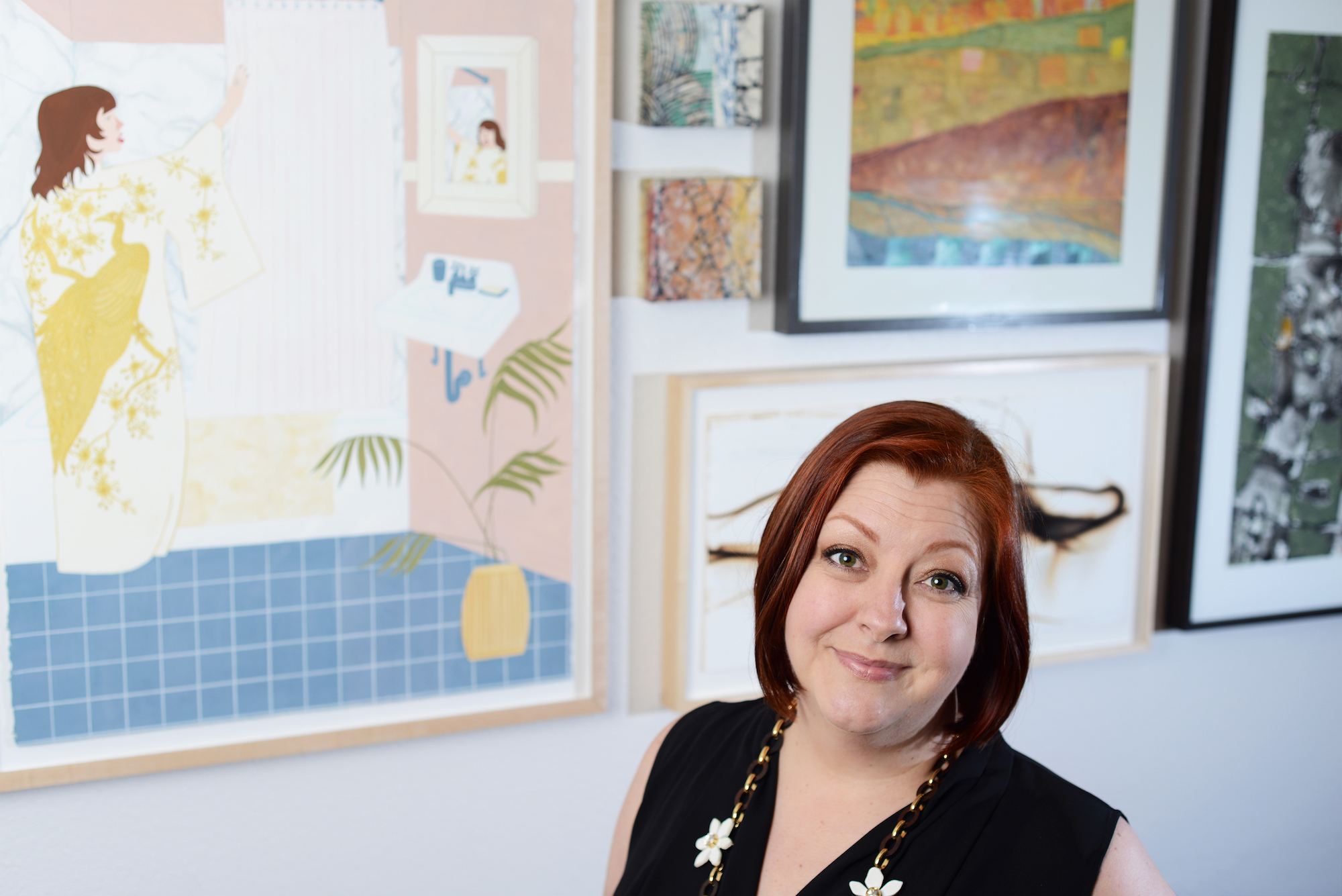 a woman in front of art on a gallery wall