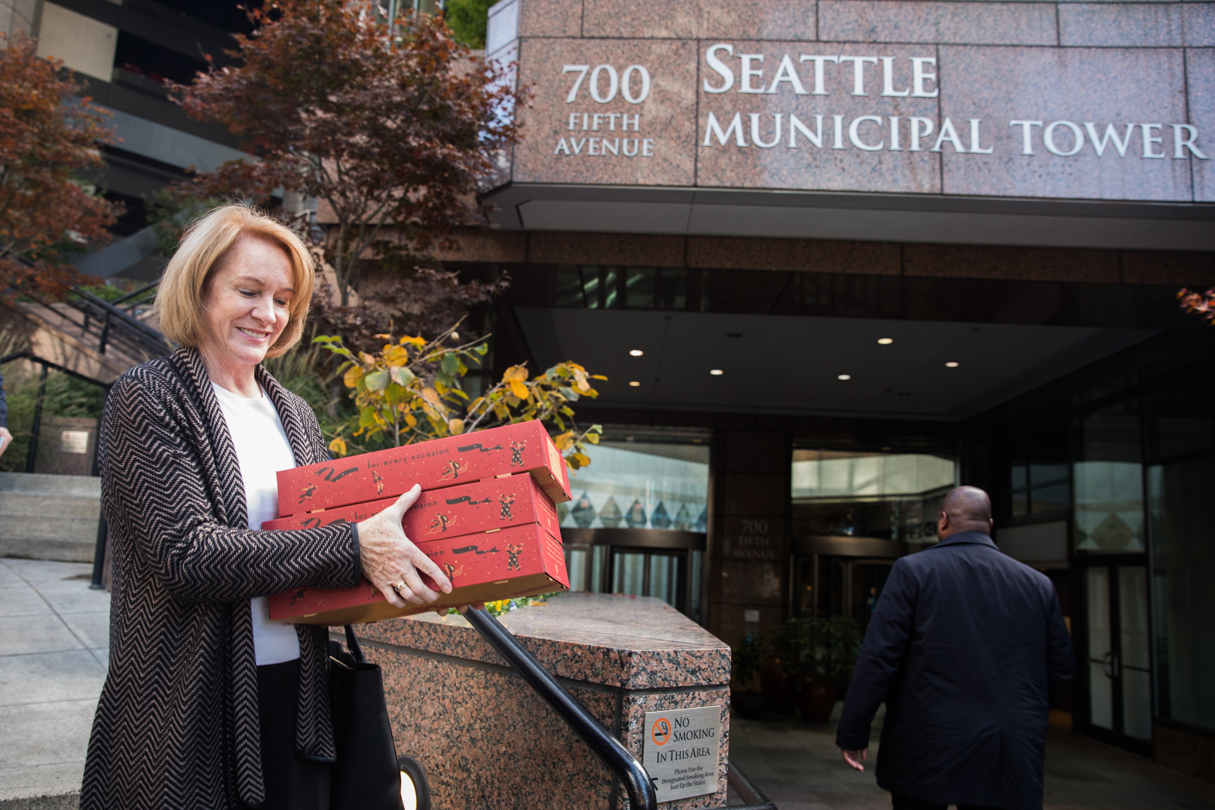 Outside the Seattle Municipal Tower, Mayor Jenny Durkan carries donuts for her staff, Nov. 8, 2018. (Photo by Matt M. McKnight/Crosscut) 