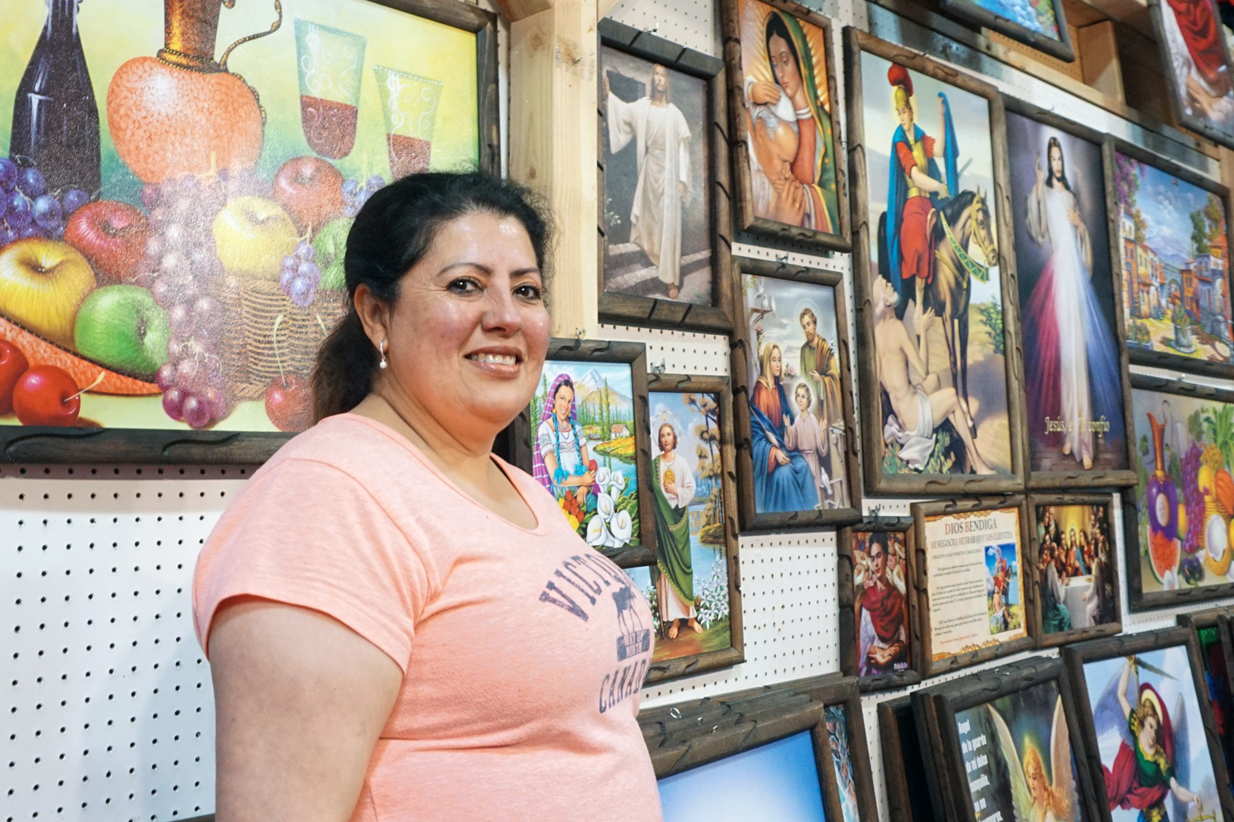 Lopez poses with her framed art work she sells.