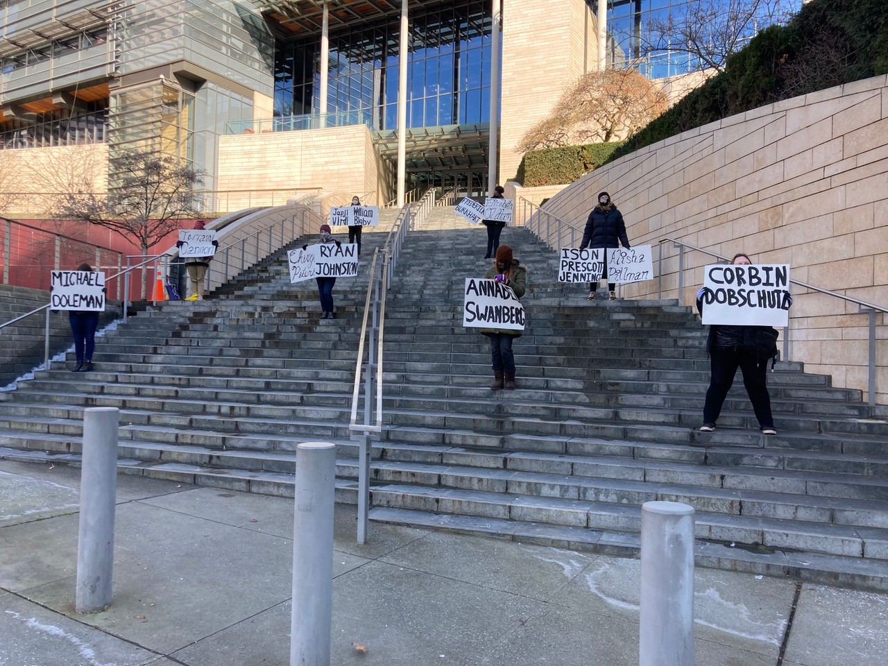 protesters holding signs of names