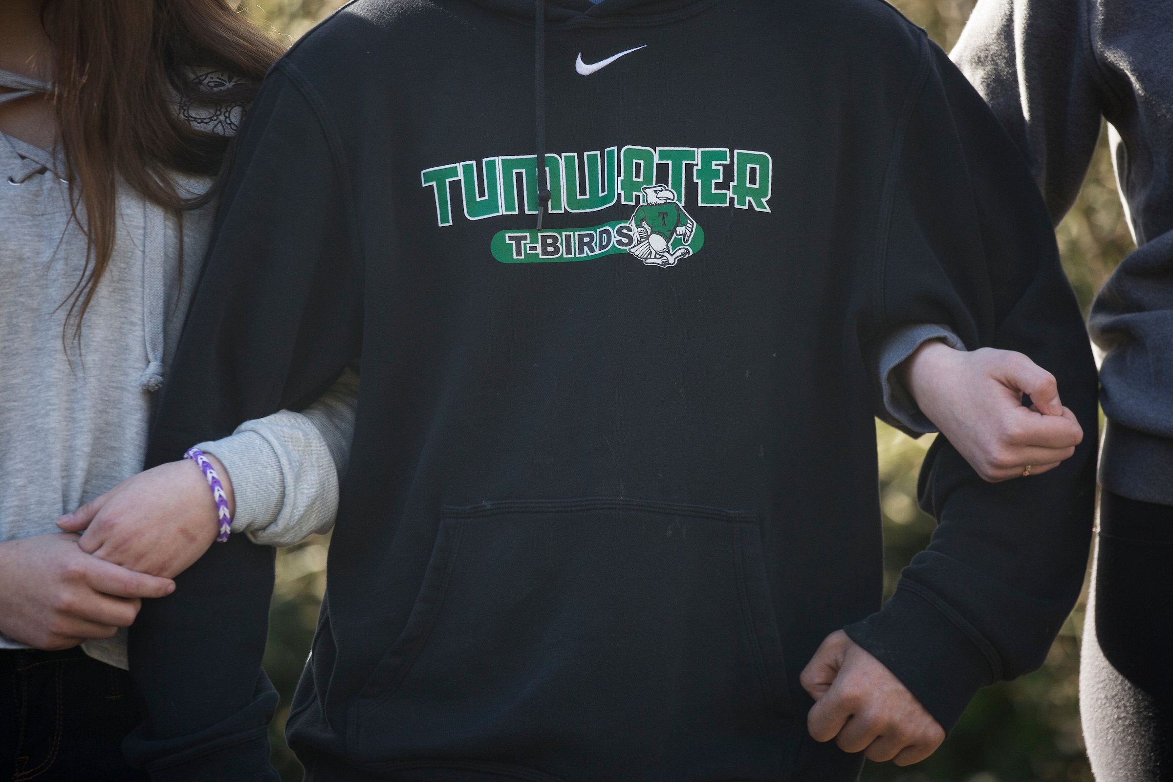 Students link arms for 17 minutes, honoring the 17 killed at a school shooting in Parkland, Florida, during a walkout and rally at Tumwater High School. (Photo by David Ryder for Crosscut)