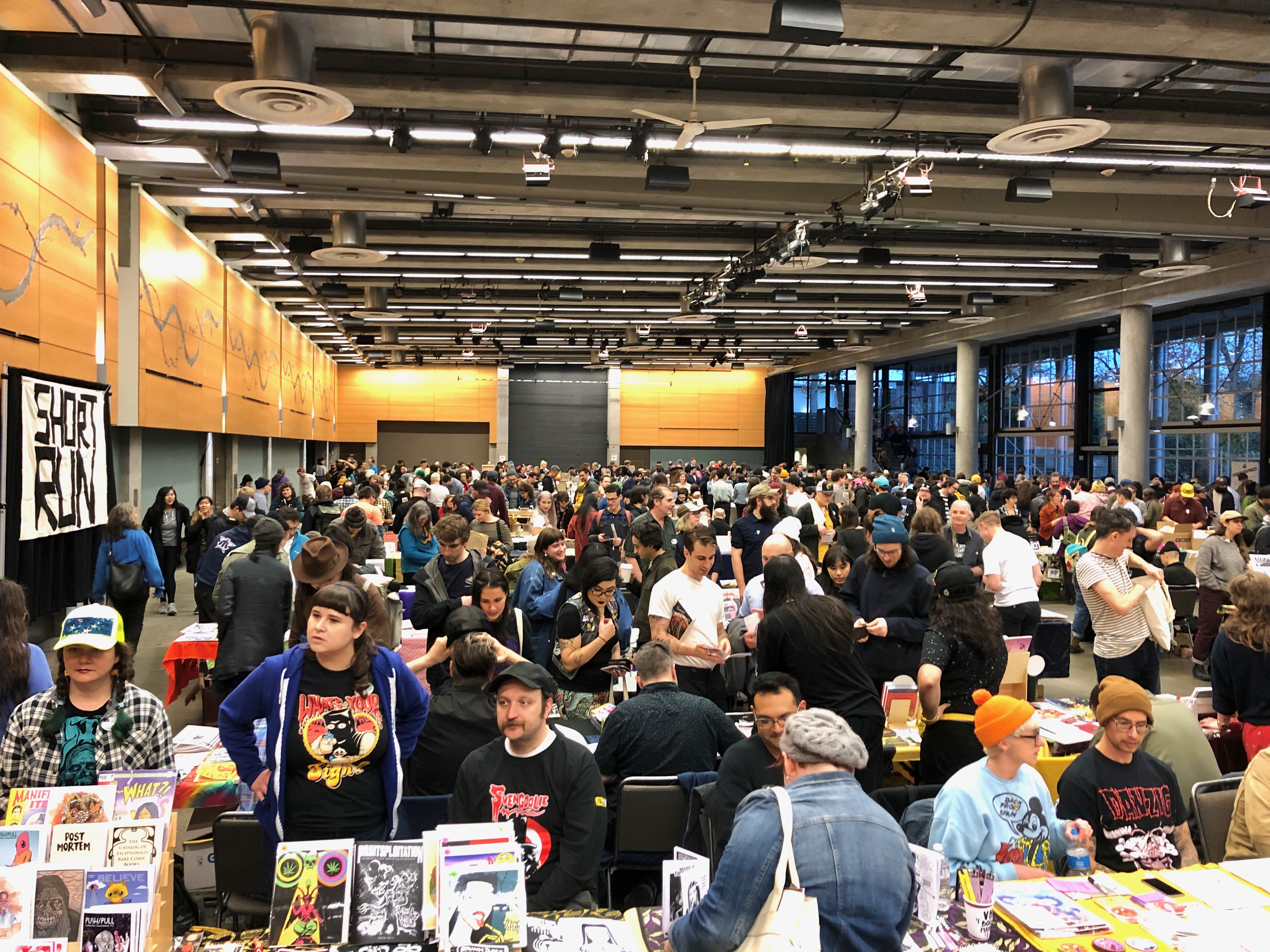 exhibit hall full of people at booths