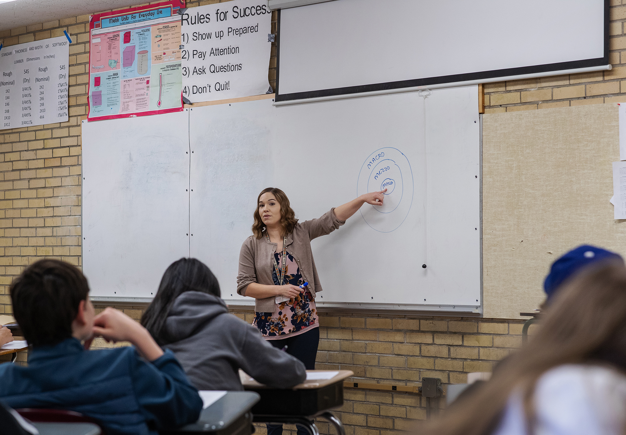 Tasha Willoughby talks to high schoolers in front of a chalkboard