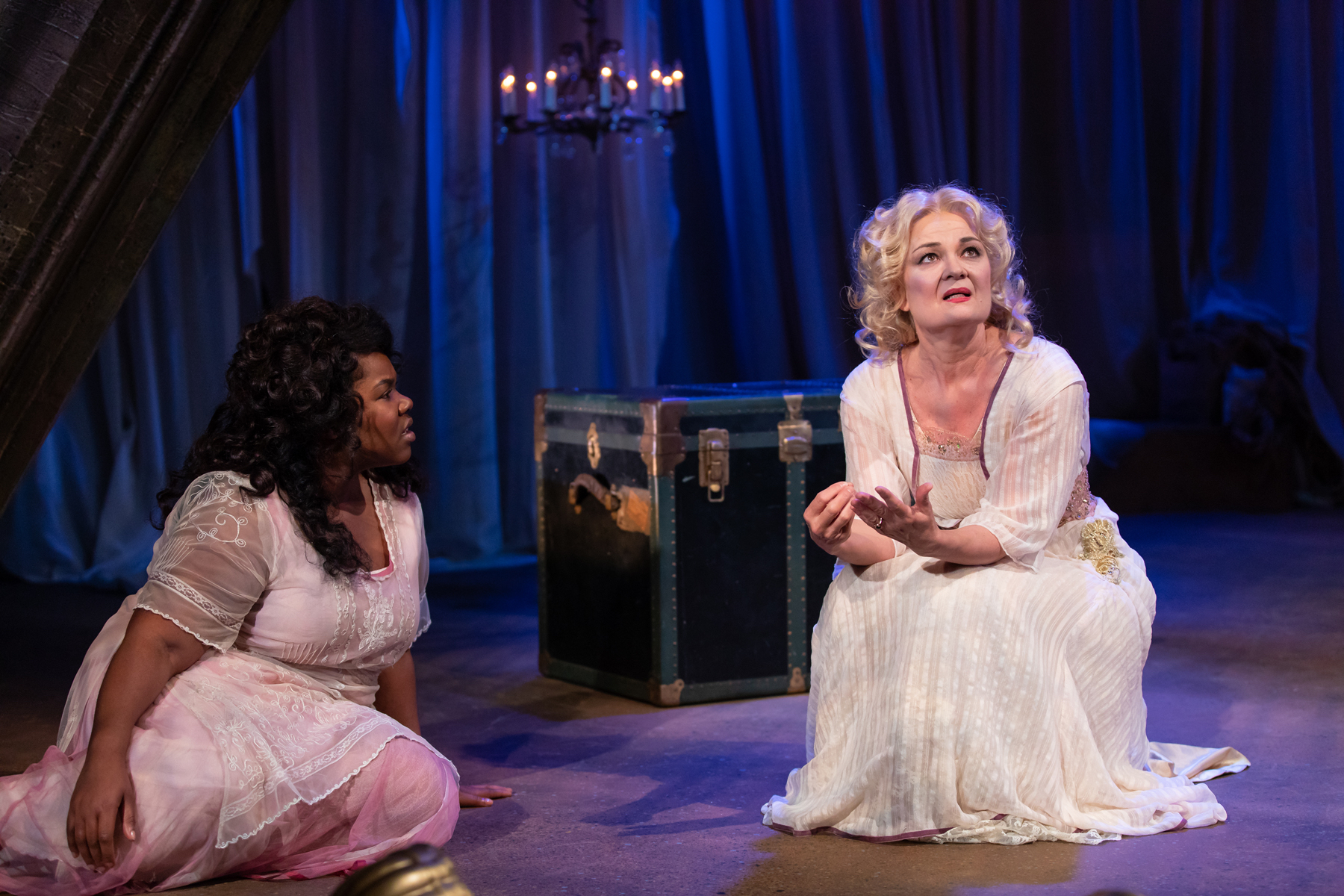 two women kneel on the floor on the set of The Tempest