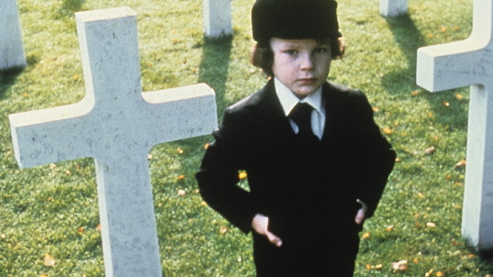 a creepy little boy in a graveyard