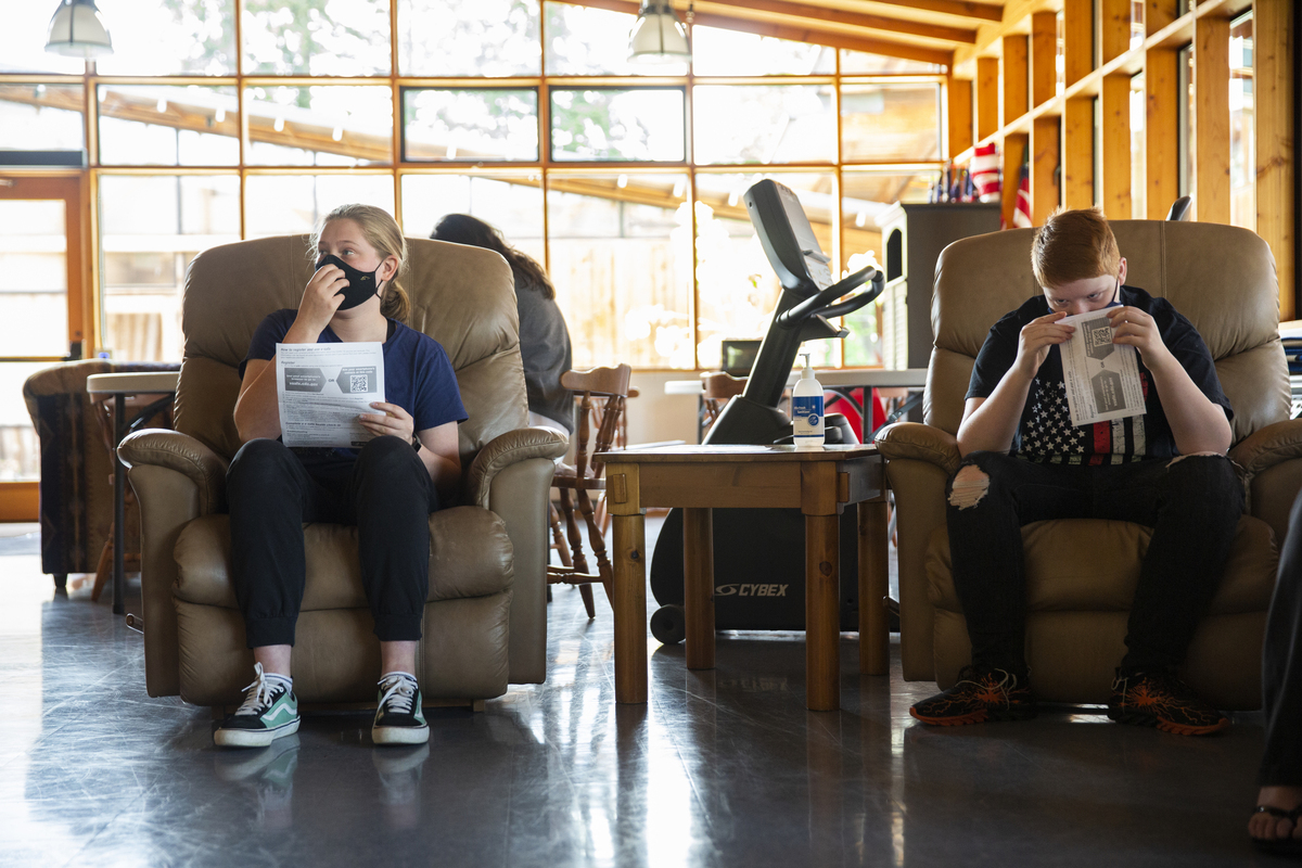 Two students waiting in chairs for vaccine