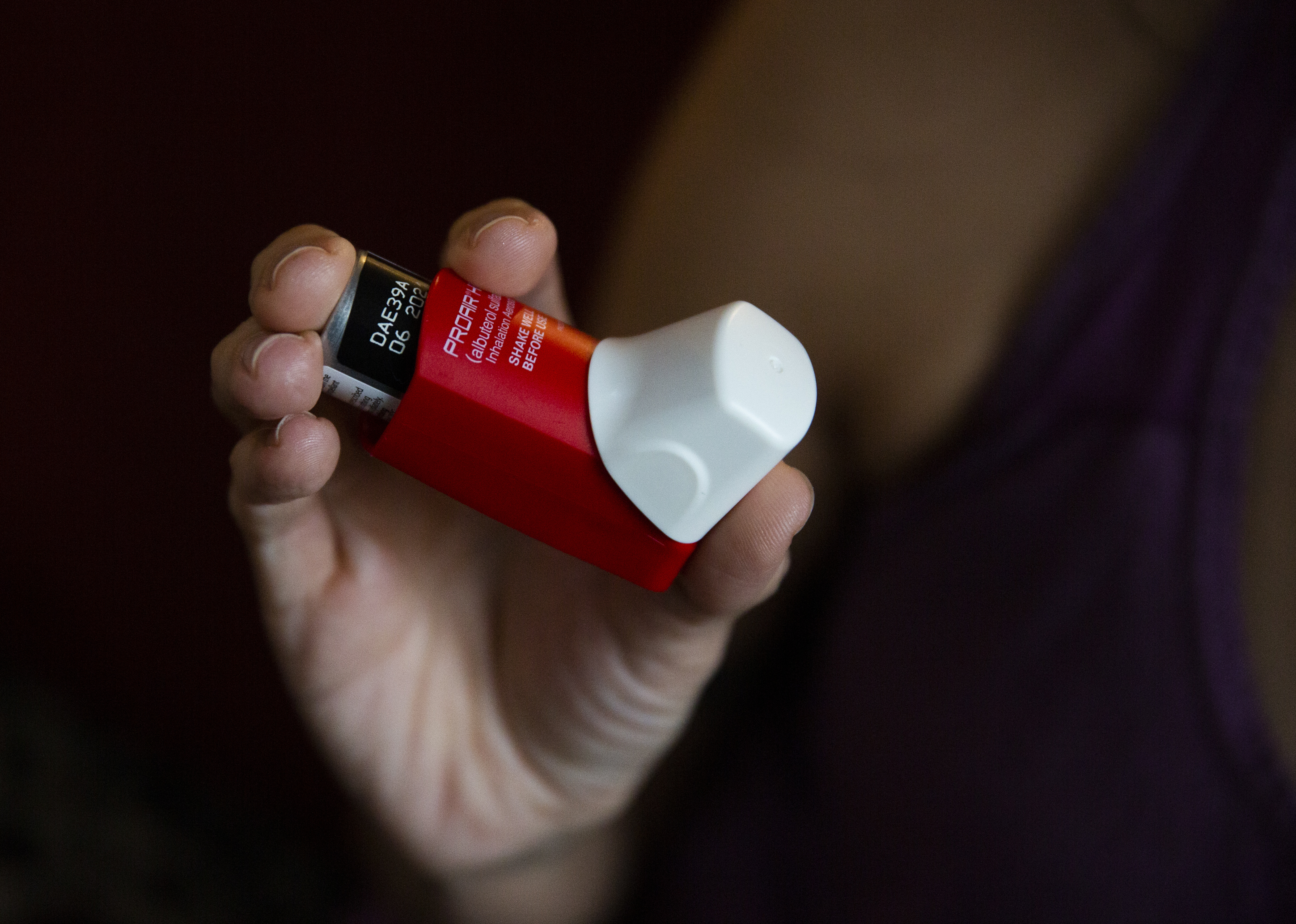 Melissa holds an inhaler