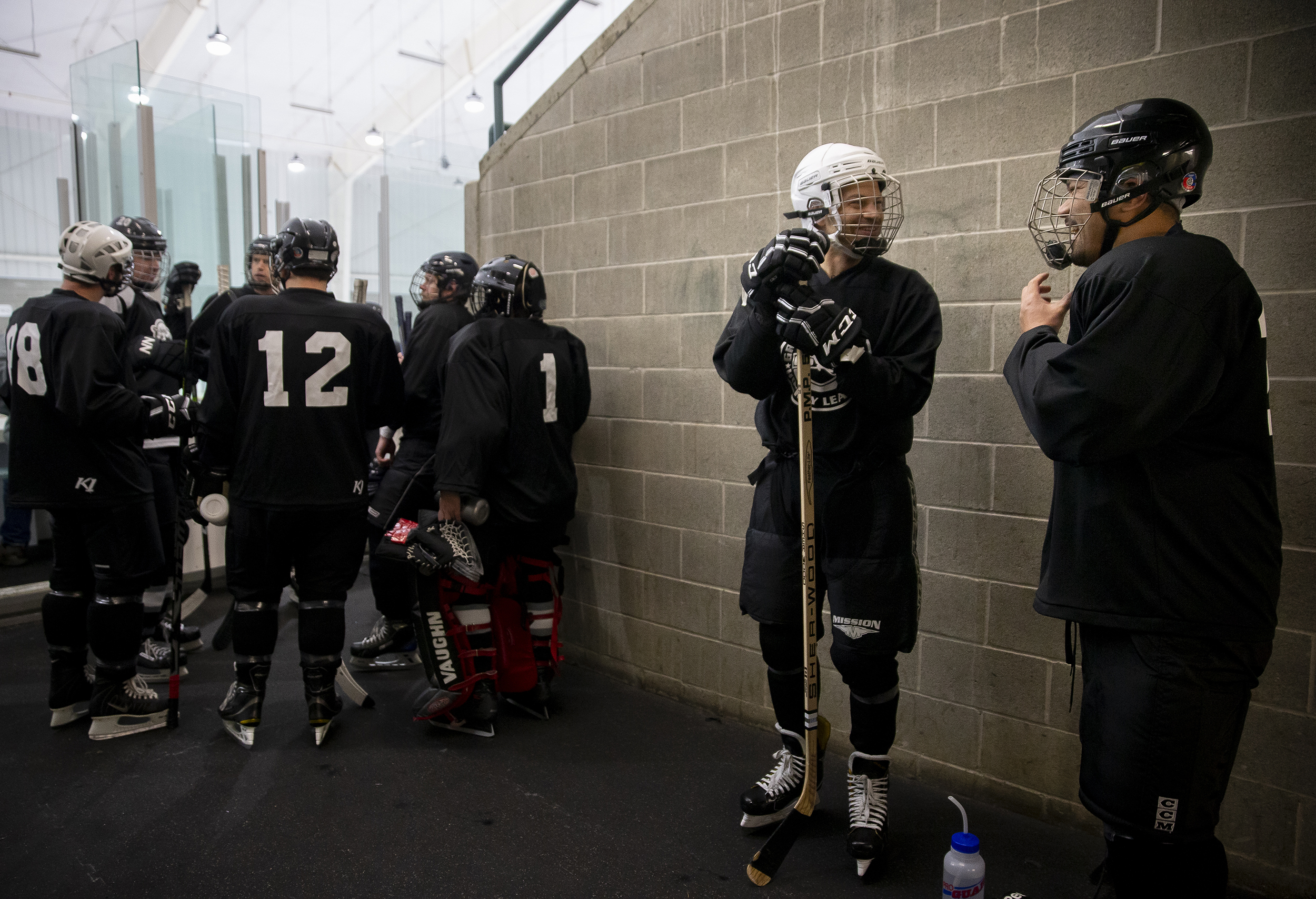 Jonathan Westmaas, second from right, talks with Reiner Blanco as he puts his helmet on before the Trash Pandas 7's second game.