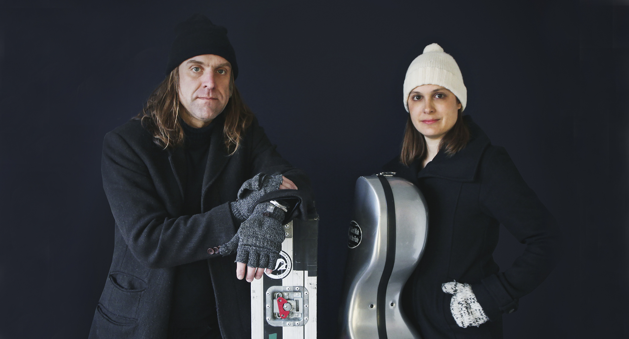 a male and female musician face the camera