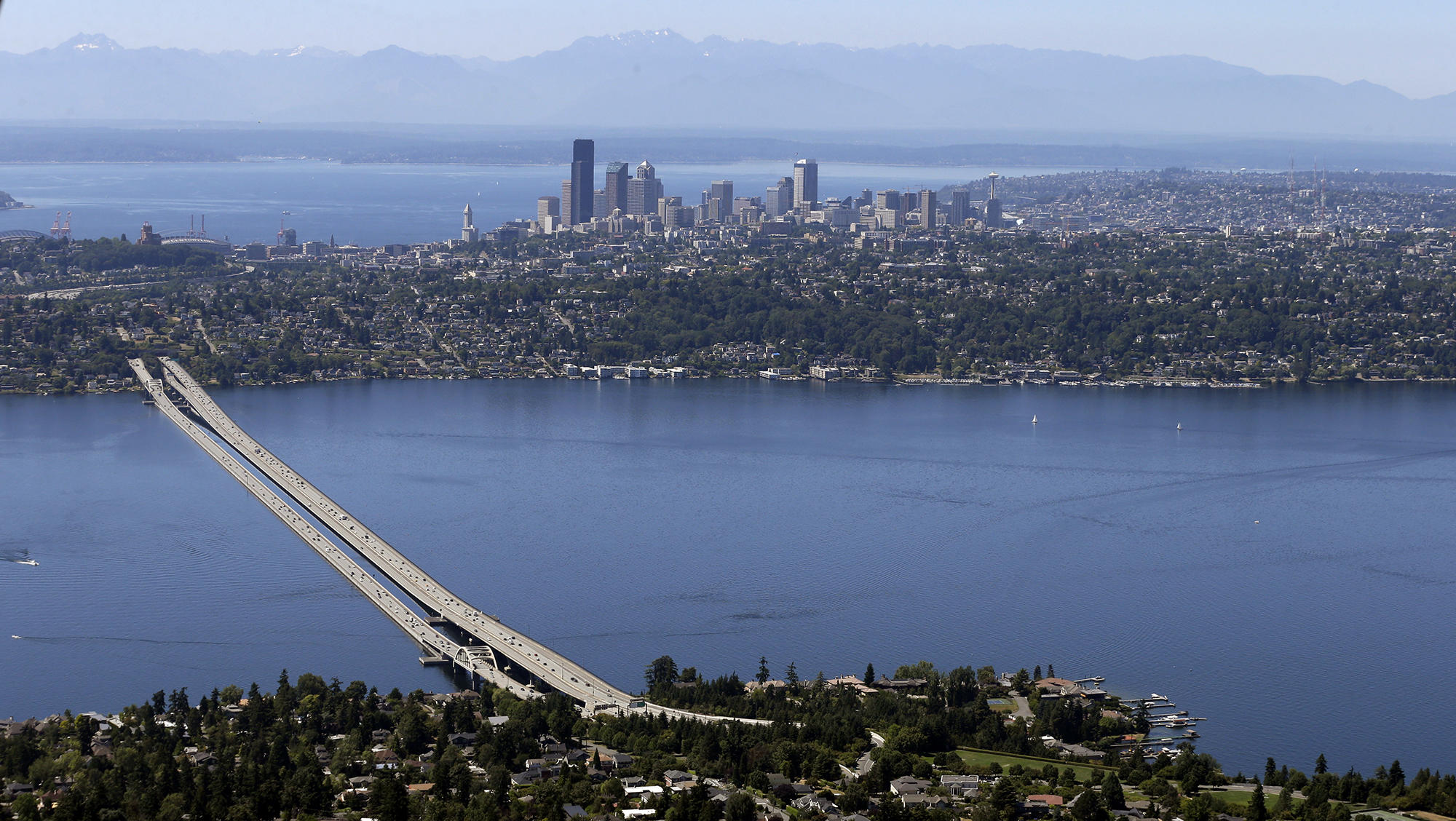 a panoramic view of lake washington, the i-90 bridge, and seattle skyline in the background