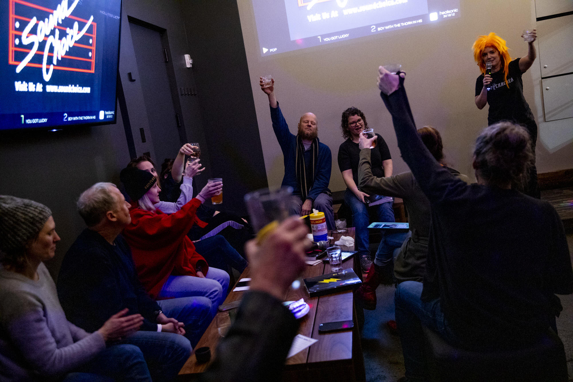 People raise their glasses in a circle