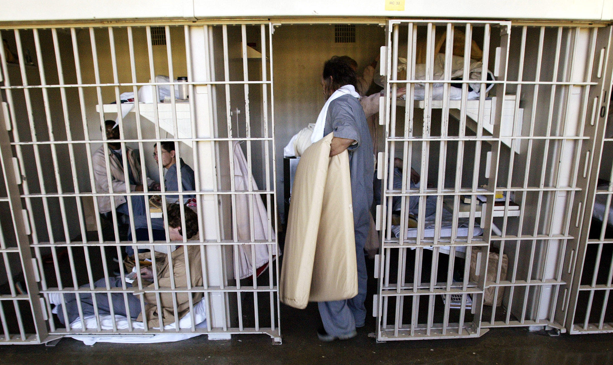 man with mat enters cell