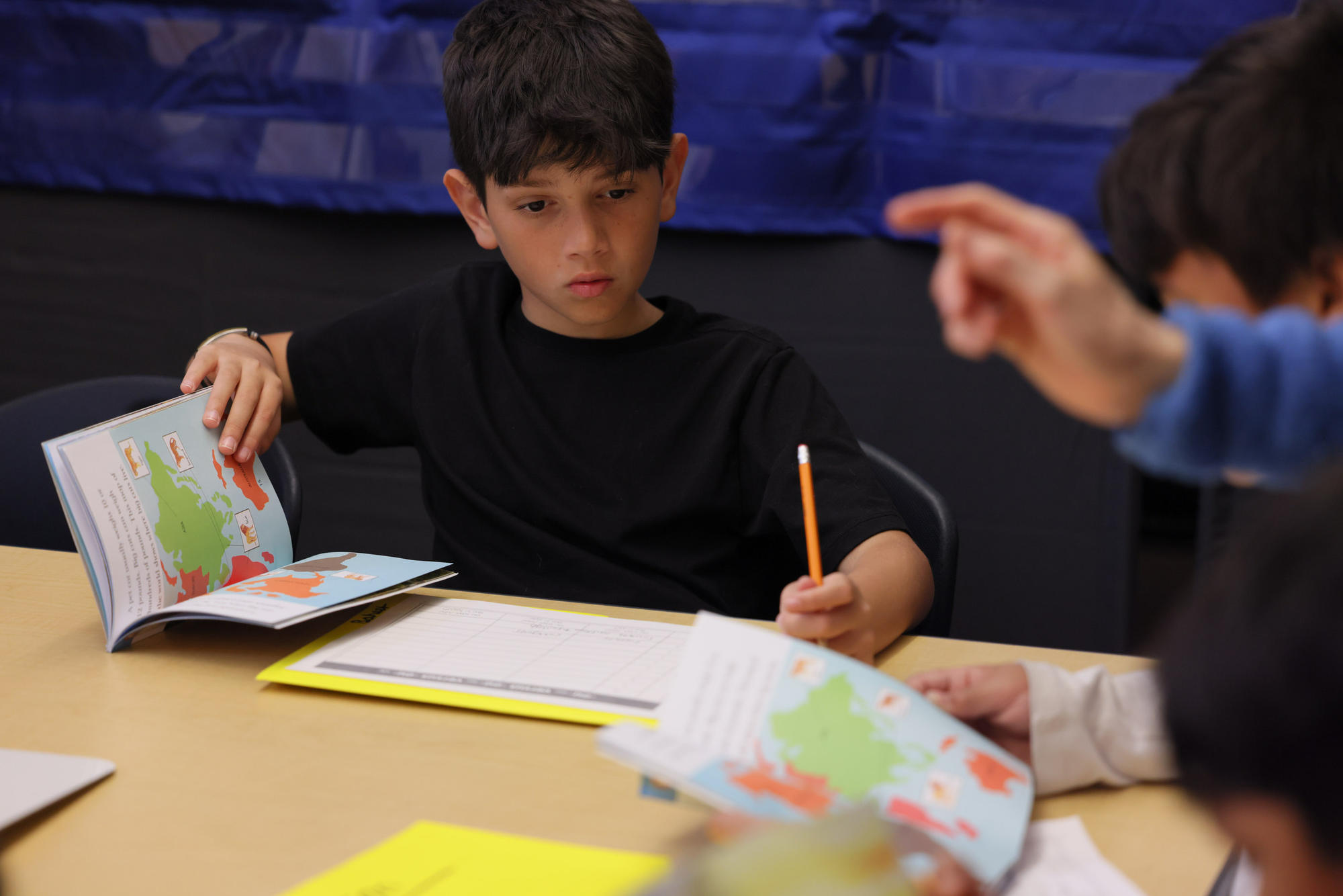 Baheer Heyadee, 10, works on reading skills with classmates at Parkside Elementary. Many of Baheer’s friends at school are from immigrant families as well. (Genna Martin/Cascade PBS) (Genna Martin/Crosscut)