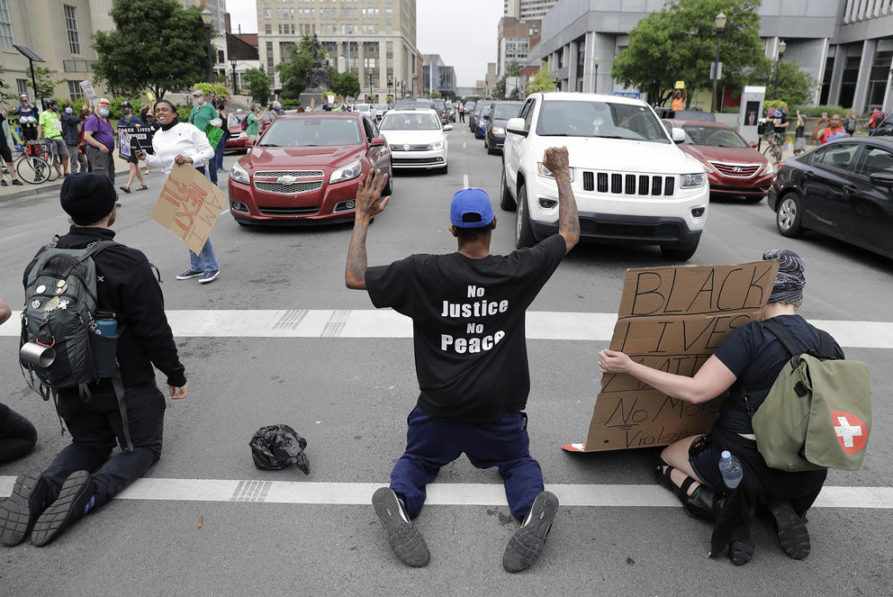 Protesters kneeling in the street