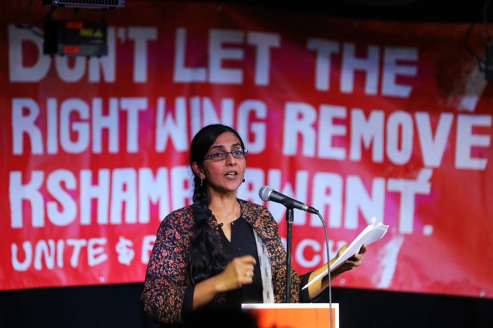 Kshama Sawant in front of banner