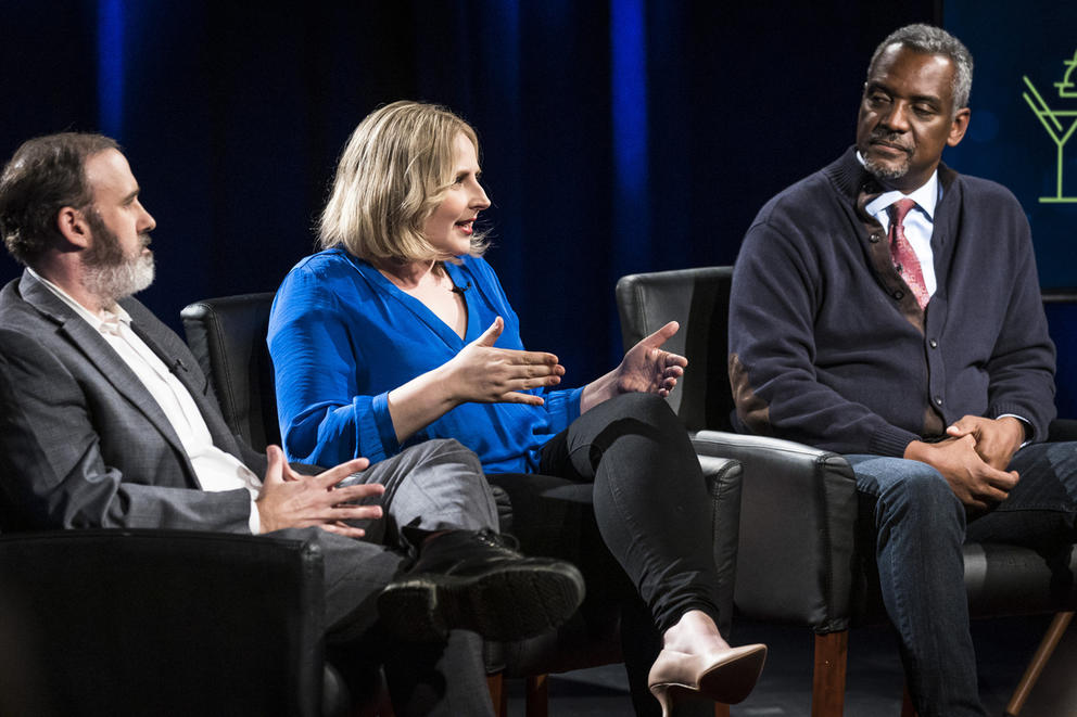 Three people sitting on stage