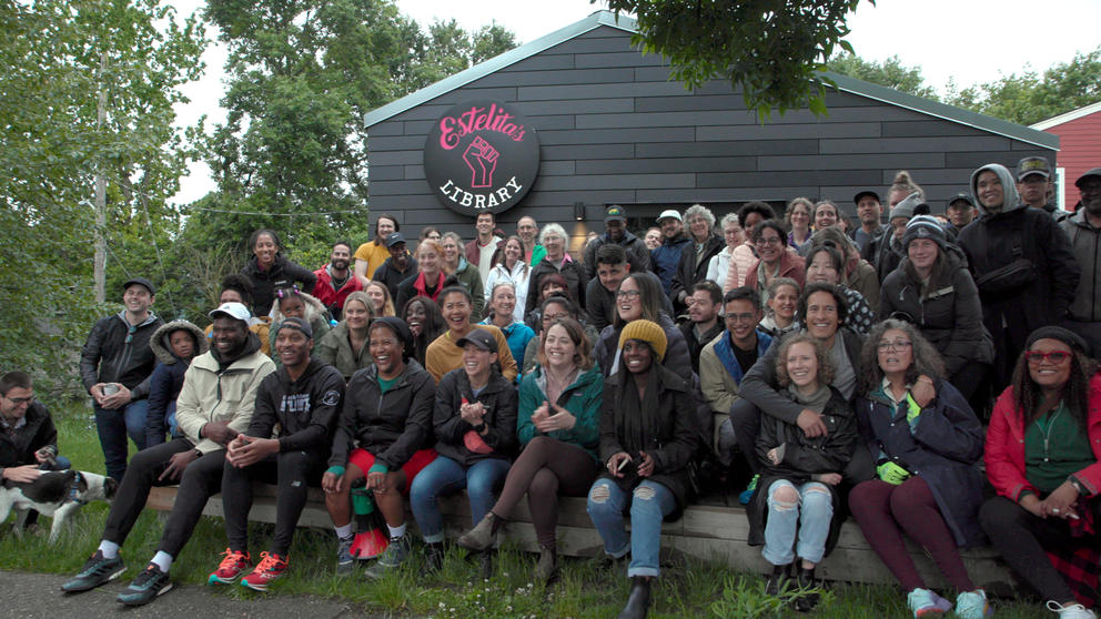 Large group of people posing in front of a business