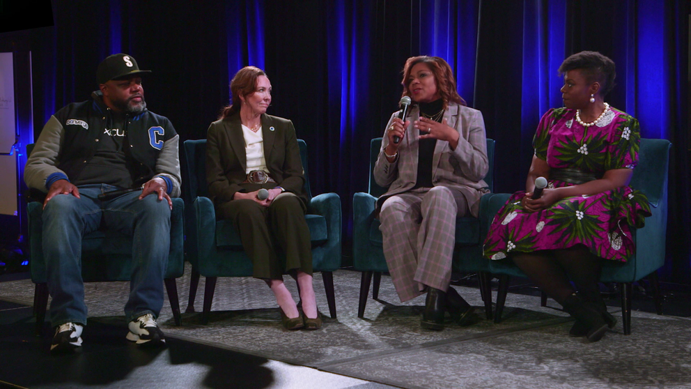 Four people sitting on a stage