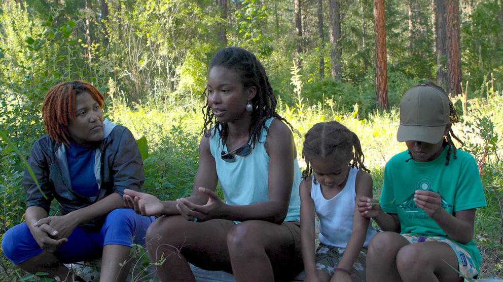 Two woman and two children sitting in the forest