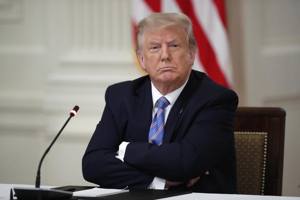 Trump crosses his arms during a meeting