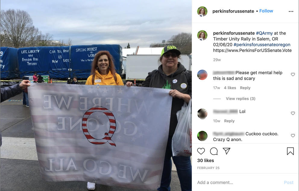 Facebook screengrab of Jo Rae Perkins posing with a QAnon banner