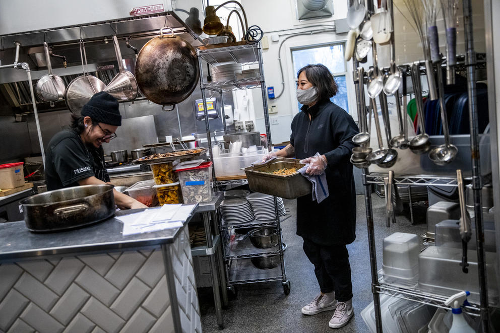 woman with large tray in hands in a professional kitchen