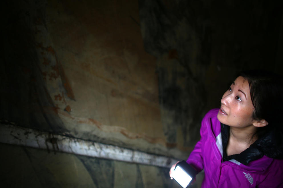 Tanya Woo checks out old murals lining a staircase that used to lead to a 1920s-era jazz club in Seattle.