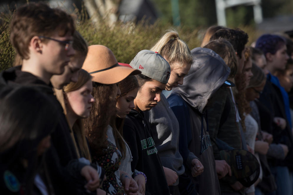 Students stand in a line and link arms for 17 minutes, honoring the 17 killed at a school shooting in Parkland, Florida