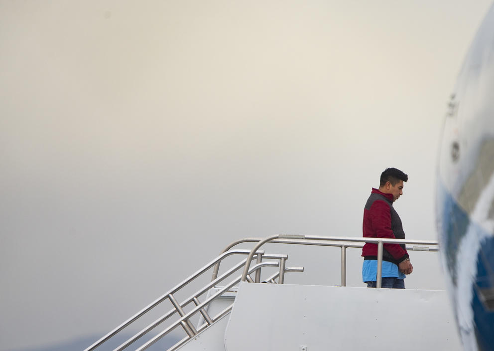 A man boards an airplane for deportation