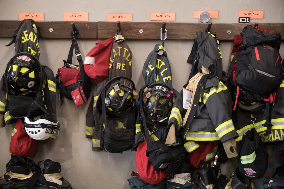 Firefighting hear hung up on a wall on hooks.