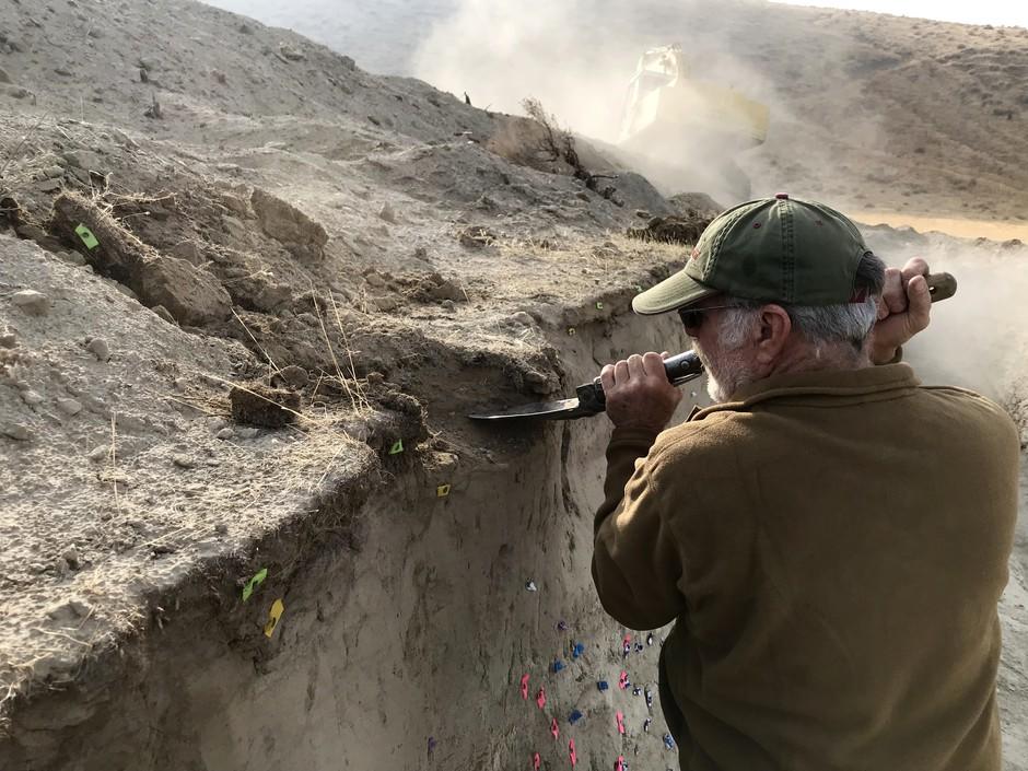 A geologist digs at a fault line