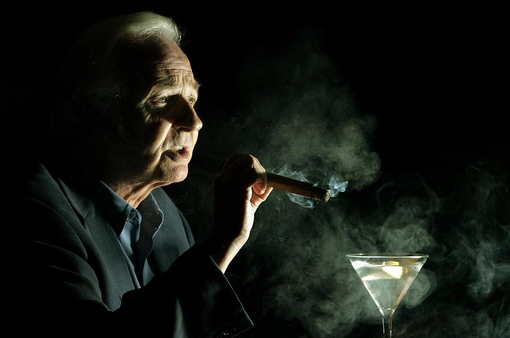 Al Swift smokes a cigar at Shelly's Backroom restaurant, Monday, Aug. 22, 2005, in Washington. (Photo by Haraz Ghanbari/AP)